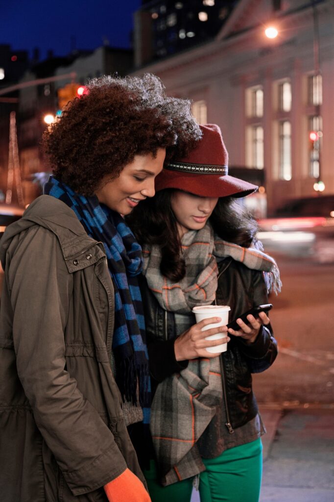 Women using cell phone on city street